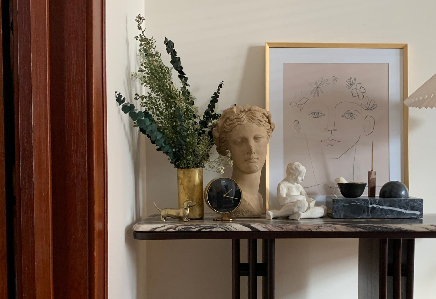 Console table displaying home decor items and art